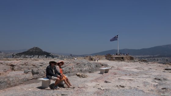 Visitors sit on a bench on the Acropolis hill, during a heatwave in Athens, Greece, July 13, 2023. REUTERS/Louiza Vradi