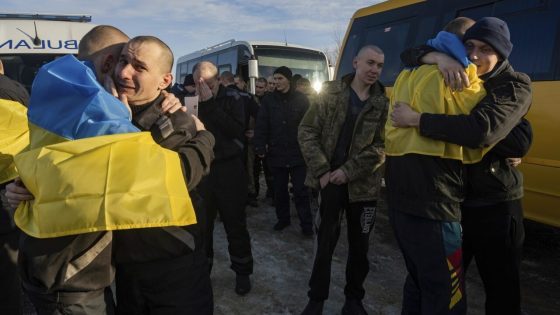 Recently swapped Ukrainian prisoners of war covered in national flags hug each other after a prisoner exchange on the Ukrainian Russian border, on Wednesday, Jan. 31, 2024. Russia and Ukraine have exchanged about 200 prisoners of war each, the countries said Wednesday, despite tensions stemming from last week's crash of a military transport plane that Moscow claimed was carrying Ukrainian POWs and was shot down by Kyiv's forces. (AP Photo/Danylo Pavlov)