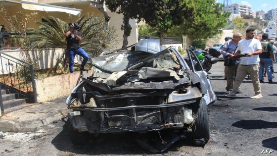 Lebanese security and emergency personnel gather around a burnt car that was reportedly targeted in an Israeli drone strike in the Abra area of the southern city of Sidon, on August 26, 2024. (Photo by Mahmoud ZAYYAT / AFP)