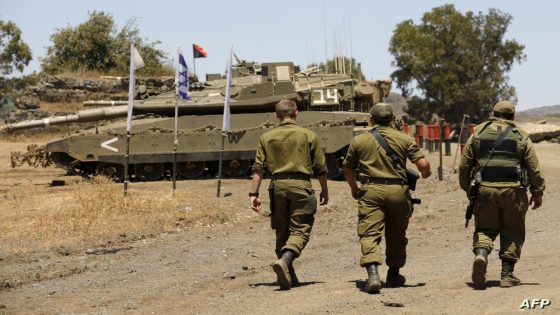 Israeli soldiers are pictured in front of Merkava battle tanks, near Moshav of Alonei Habashan, in the Israel-annexed Golan Heights, on July 22, 2022. - An Israeli strike killed three Syrian soldiers and wounded seven others near Damascus early today, the Syrian defence ministry said. (Photo by JALAA MAREY / AFP)